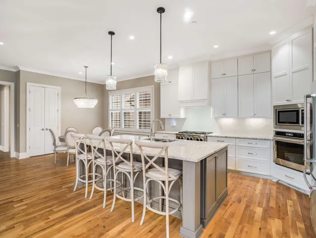 a kitchen with stainless steel appliances granite countertop a stove a sink and a refrigerator