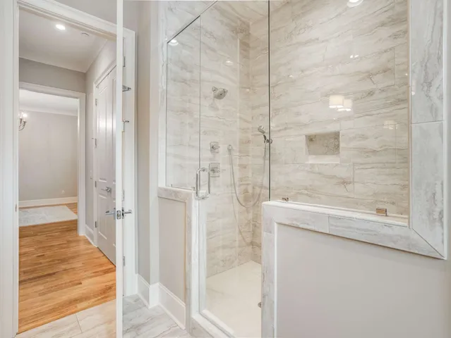 a view of an empty room with wooden floor and windows
