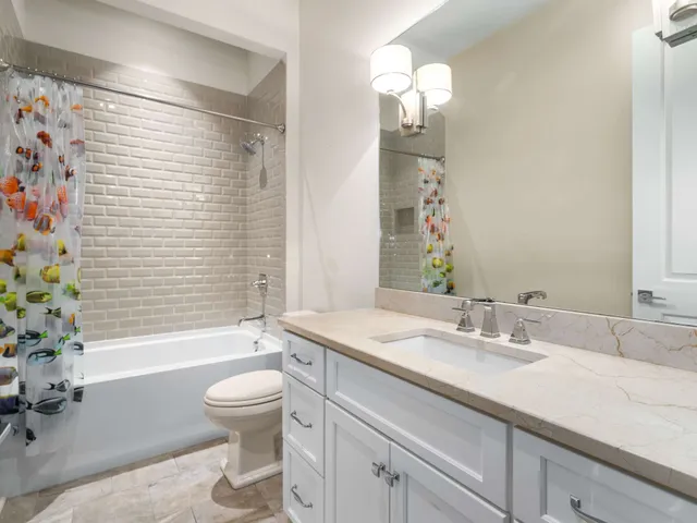 front view of a house with potted plants and large trees