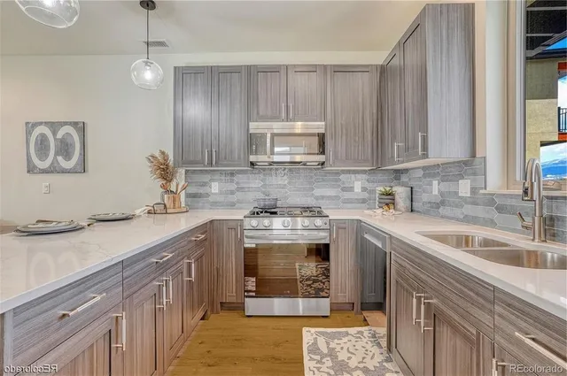 a kitchen with stainless steel appliances granite countertop a sink stove and cabinets