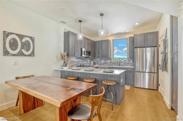 a kitchen with kitchen island a sink stove and refrigerator