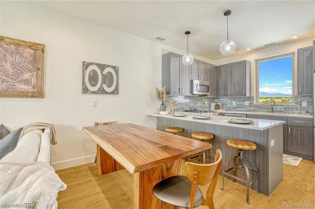 a kitchen with a table chairs a sink dishwasher window and cabinets
