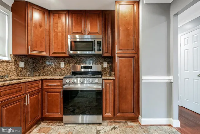 a kitchen with stainless steel appliances granite countertop a stove and a refrigerator