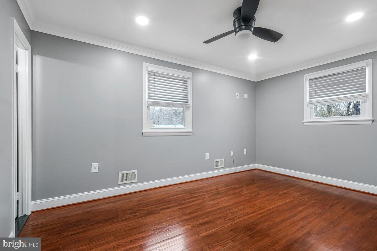 6912 Eilerson Street Clinton, MD 20735 - Photo 17 of 28 a view of an empty room with wooden floor and a window