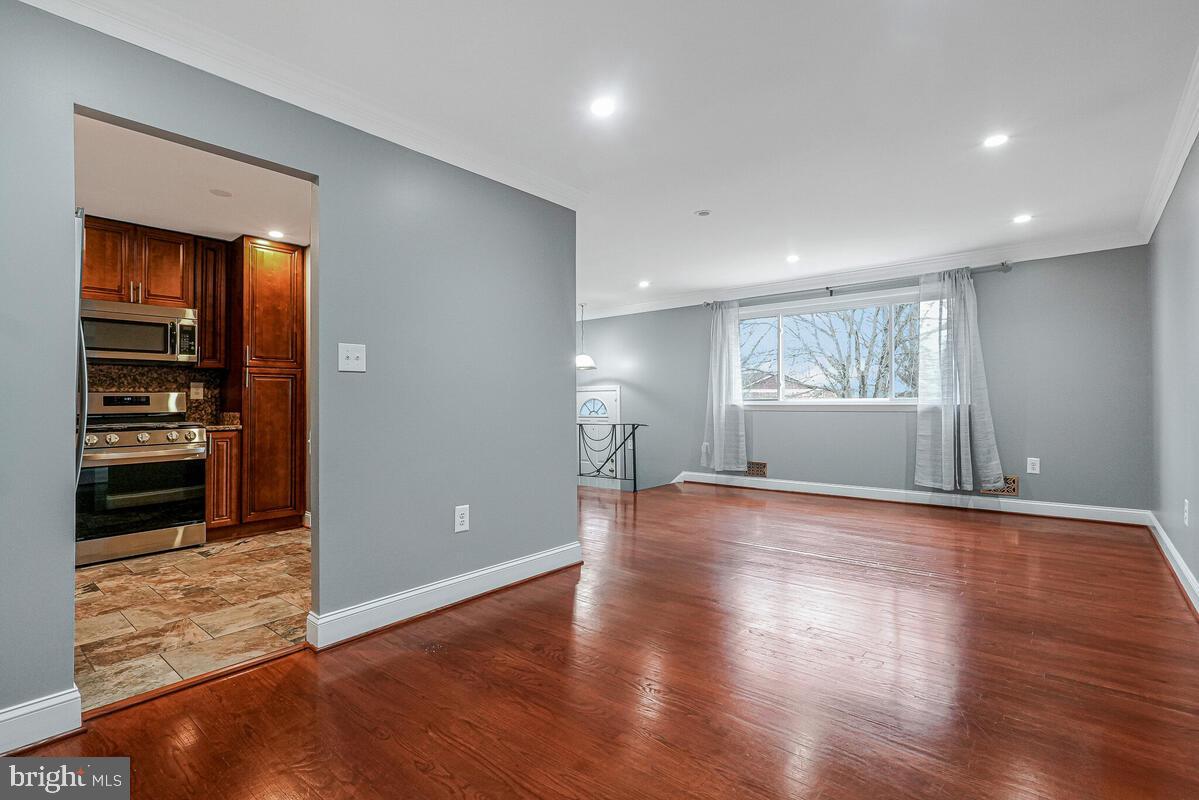 6912 Eilerson Street Clinton, MD 20735 - Photo 8 of 28 a view of empty room with wooden floor and kitchen