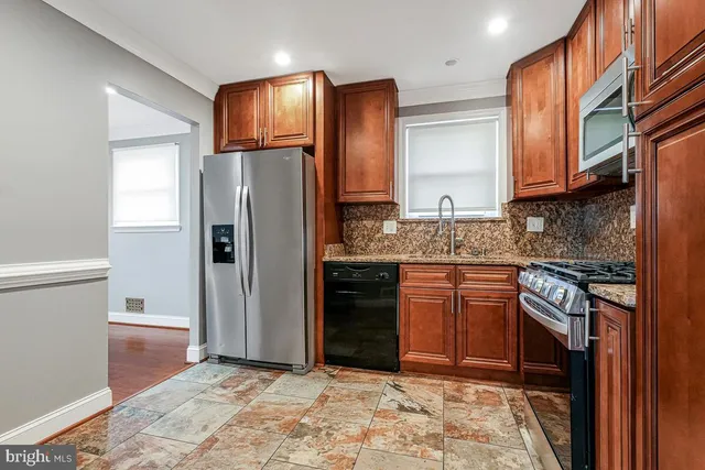 a kitchen with stainless steel appliances granite countertop a refrigerator stove and sink