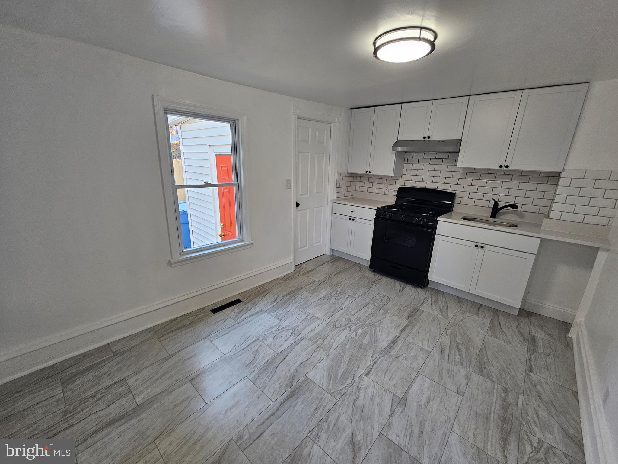 221 Broadway Westville, NJ 08093 - Photo 28 of 51 a kitchen with granite countertop a stove a sink and a refrigerator