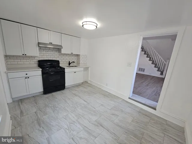 a view of a room with wooden floor and small window