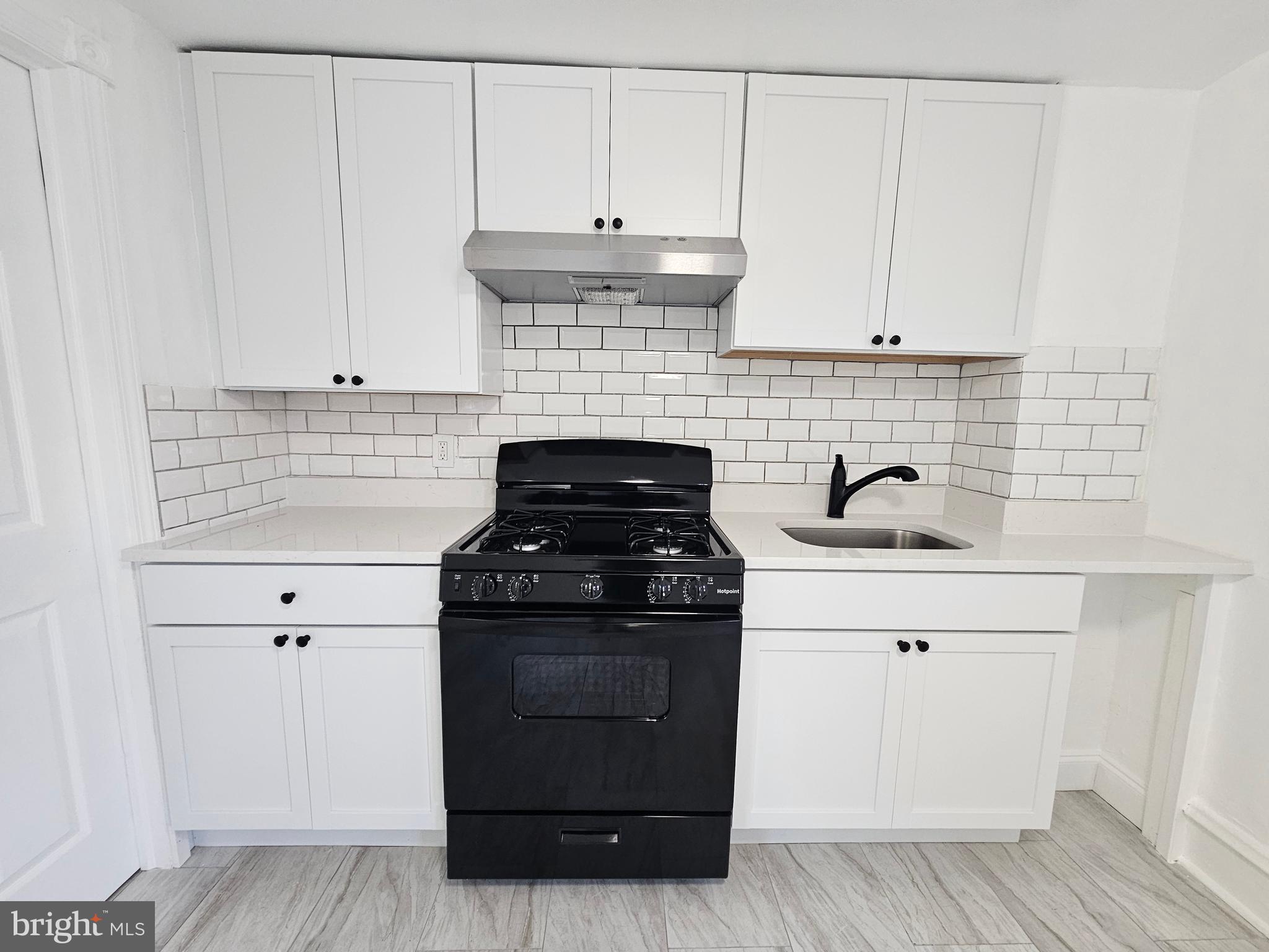 221 Broadway Westville, NJ 08093 - Photo 30 of 51 a kitchen with granite countertop white cabinets and black appliances