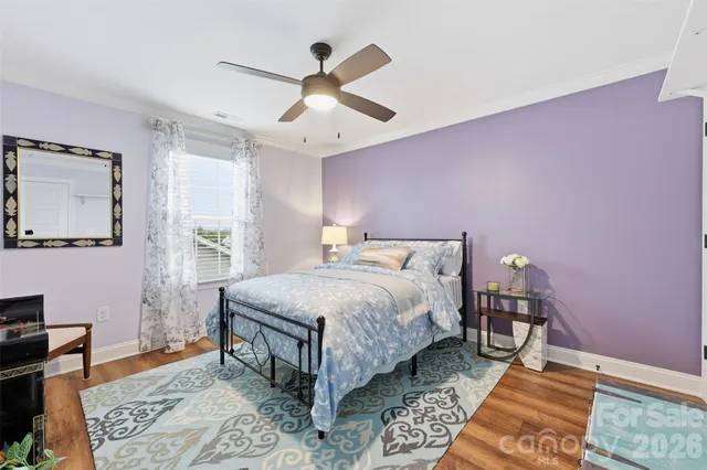 a bedroom with a bed wooden floor and a table