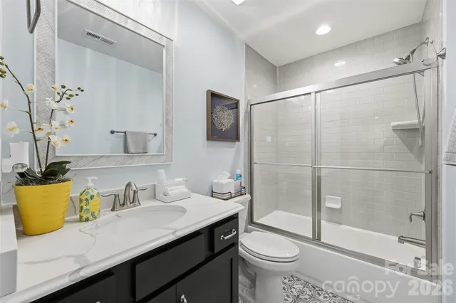 a bathroom with a granite countertop sink a toilet and shower