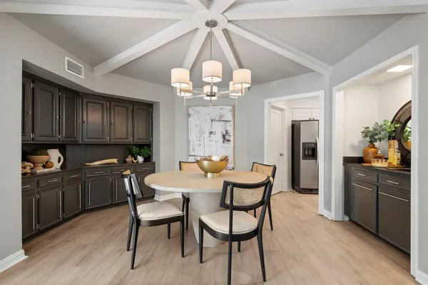 a view of a dining room with furniture a chandelier and wooden floor