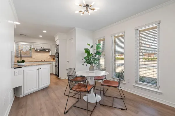 a kitchen with a dining table chairs and white cabinets