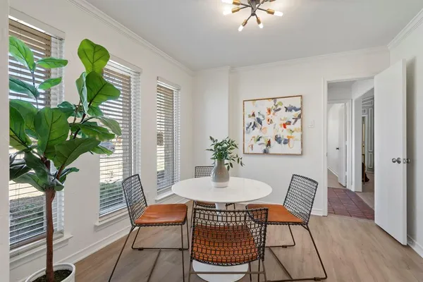 a dining room with furniture potted plants and wooden floor