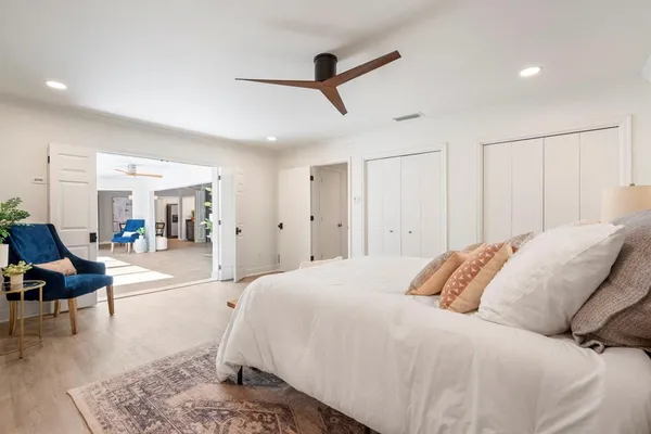a spacious bedroom with a bed a couch and a view of living room