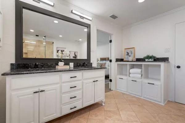 a spacious bathroom with a granite countertop sink and a mirror