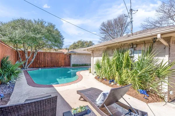 a view of backyard with potted plants and wooden fence