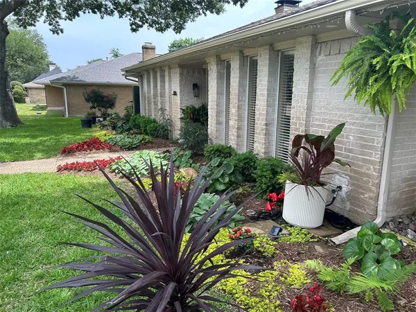 a front view of a house with a yard and potted plants