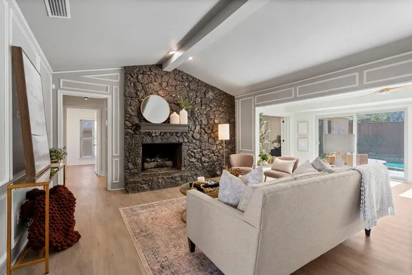 a living room with furniture a large window and a fireplace