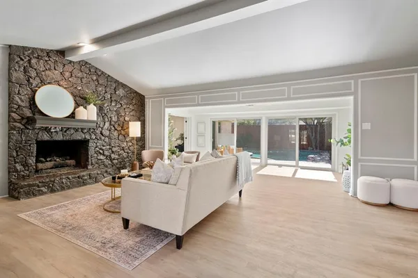 a living room with furniture a fireplace and a floor to ceiling window