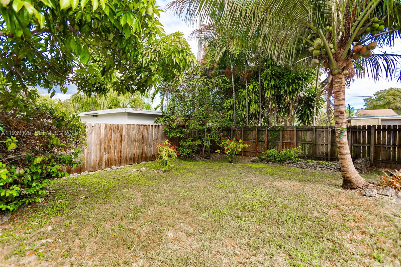 6765 Southwest 51st Street Miami, FL 33155 - Photo 22 of 43 a backyard of a house with plants and wooden fence