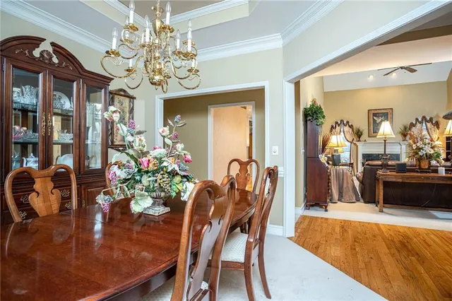 a view of a dining room with furniture a chandelier and wooden floor