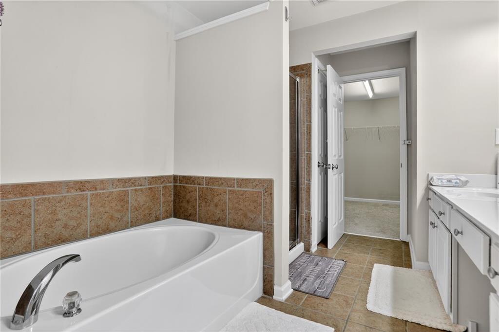 3053 Hartright Bend Court Duluth, GA 30096 - Photo 15 of 24 a bathroom with a bathtub and a shower