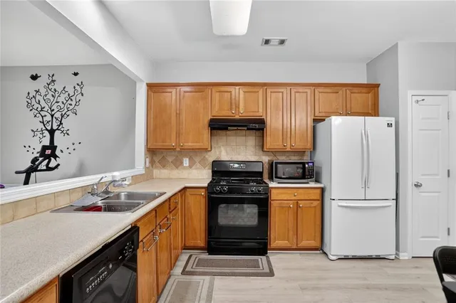 a kitchen with a refrigerator stove and sink