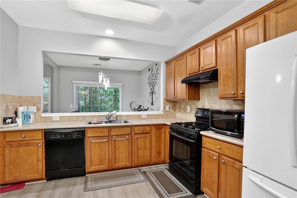 3053 Hartright Bend Court Duluth, GA 30096 - Photo 7 of 24 a kitchen with a sink and a stove top oven