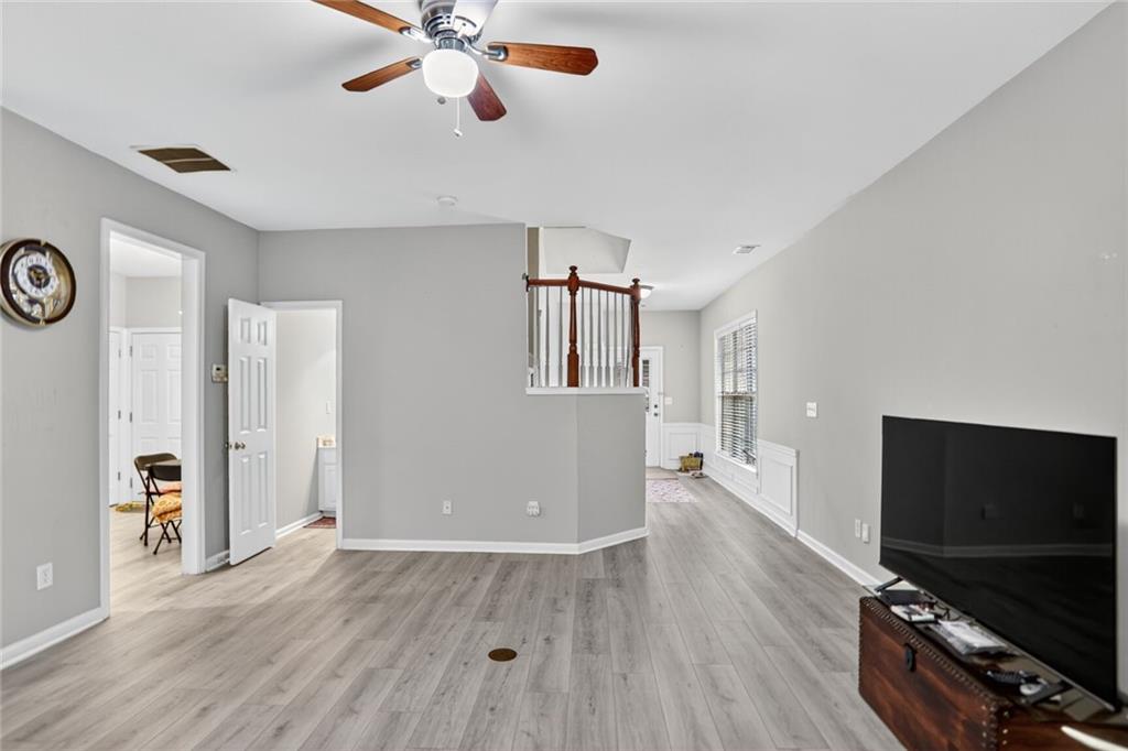 3053 Hartright Bend Court Duluth, GA 30096 - Photo 8 of 24 a view of a livingroom with a flat screen tv wooden floor and a ceiling fan