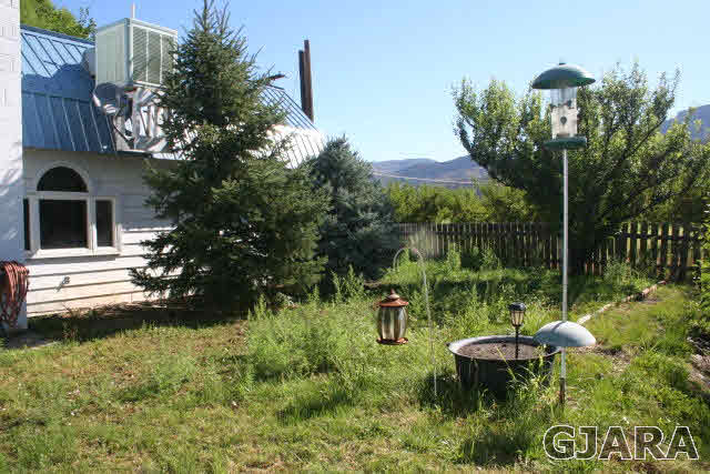 3839 G Road Palisade, CO 81526 - Photo 2 of 13 a backyard of a house with yard fountain and outdoor seating