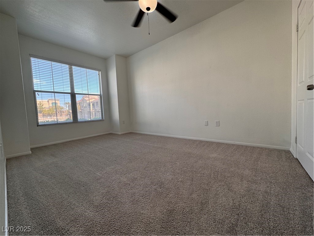 9975 Peace Way, Unit 1140 Las Vegas, NV 89147 - Photo 10 of 23 Unfurnished room featuring carpet floors, a ceiling fan, and baseboards