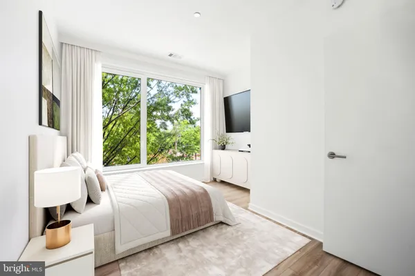 a bedroom with a bed wooden floor and window