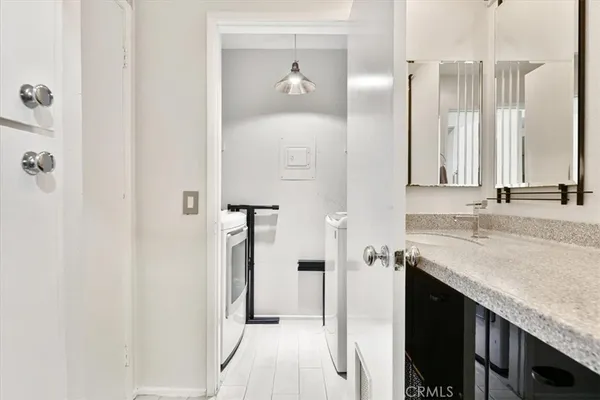 a en suite bathroom with a granite countertop sink and a mirror