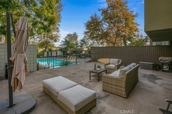 a view of a patio with couches and a table and chairs with wooden fence