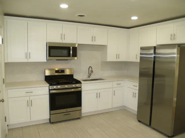 a kitchen with cabinets stainless steel appliances and a counter space
