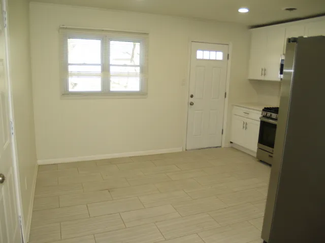 a view of an empty room with a kitchen