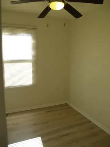 a view of a small space with wooden floor and a window