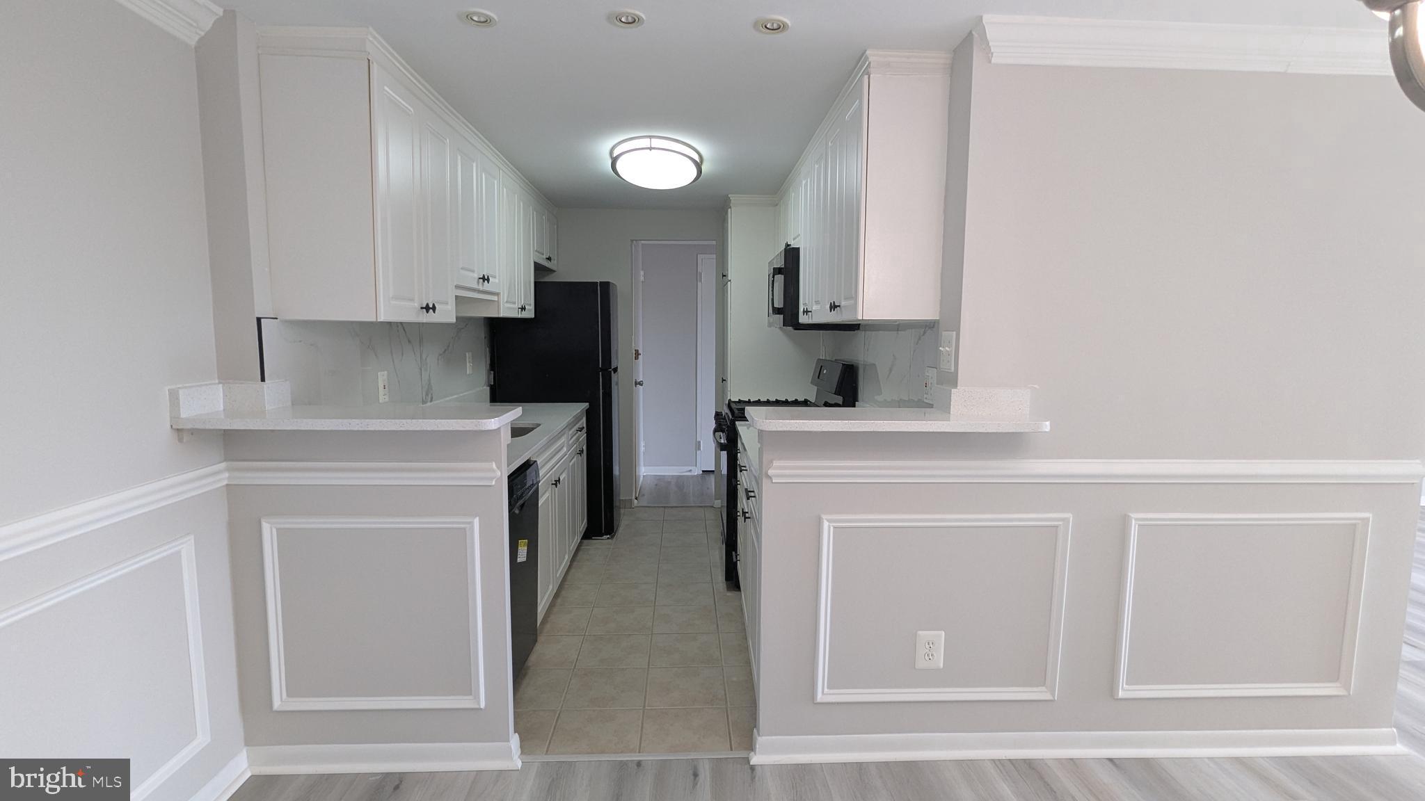 4600 Duke Street, Unit 620 Alexandria, VA 22304 - Photo 16 of 40 a kitchen with a sink cabinets and a stove top oven