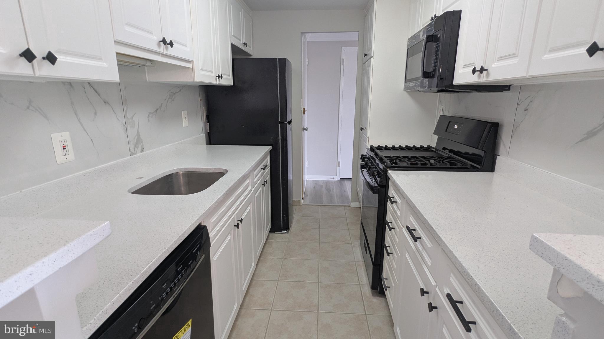 4600 Duke Street, Unit 620 Alexandria, VA 22304 - Photo 17 of 40 a kitchen with stainless steel appliances granite countertop a sink stove and refrigerator