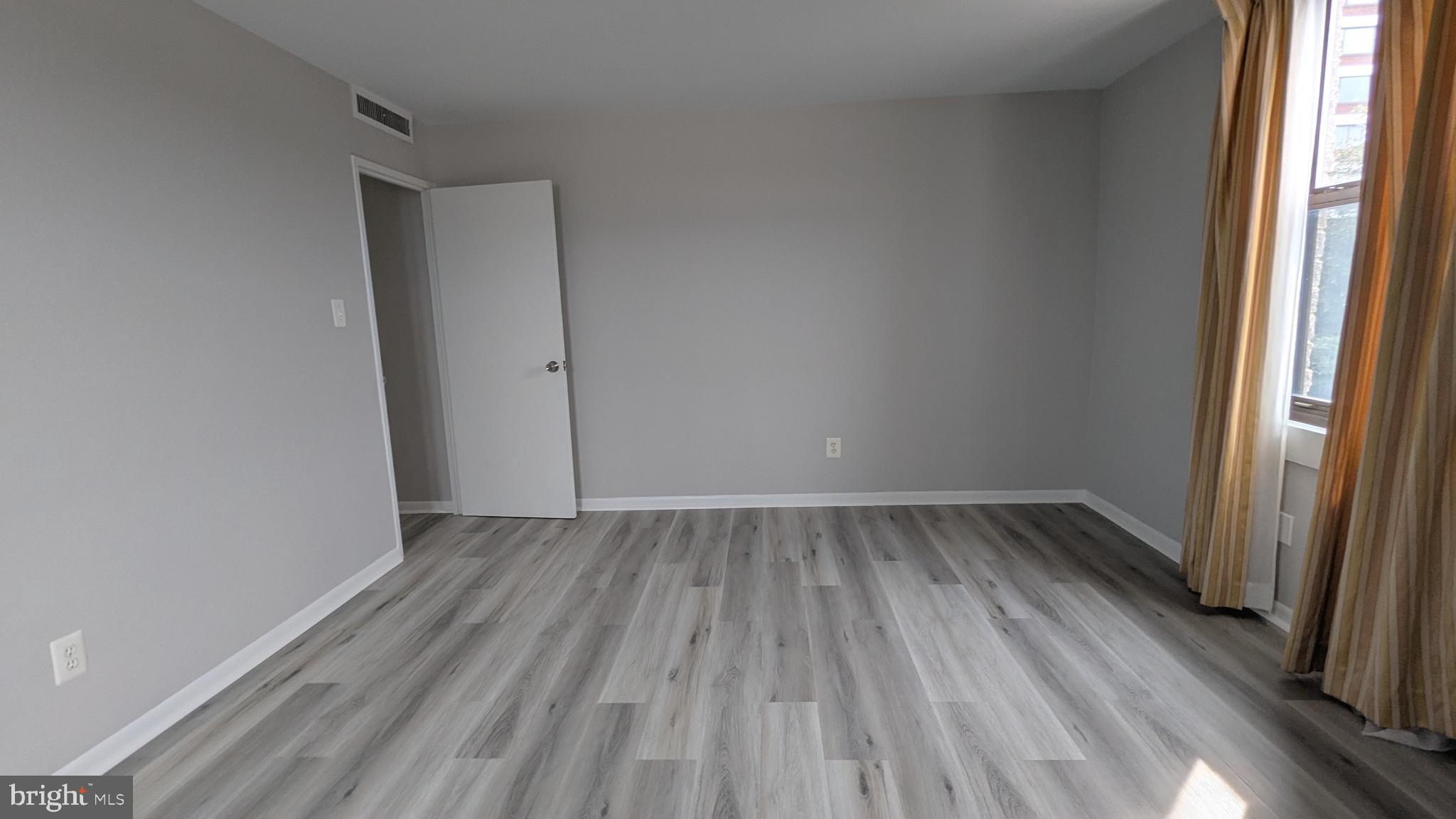 4600 Duke Street, Unit 620 Alexandria, VA 22304 - Photo 21 of 40 a view of an empty room with wooden floor and a window