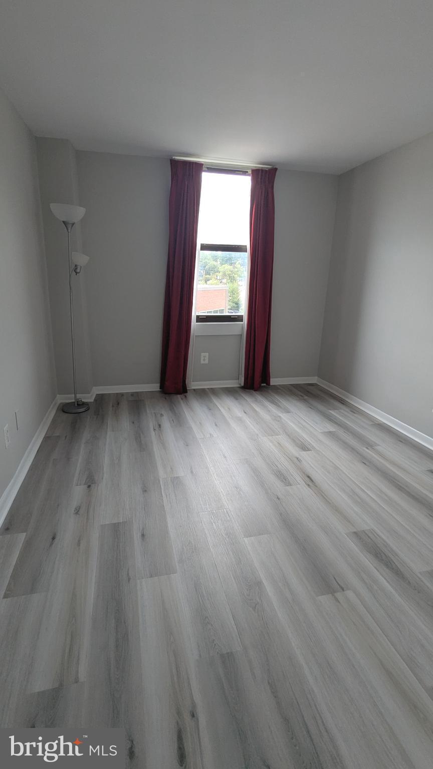 4600 Duke Street, Unit 620 Alexandria, VA 22304 - Photo 25 of 40 an empty room with wooden floor and windows