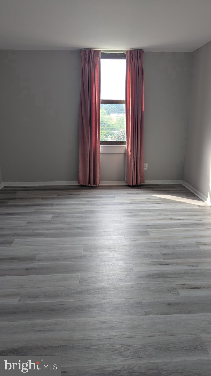 4600 Duke Street, Unit 620 Alexandria, VA 22304 - Photo 26 of 40 a view of an empty room with wooden floor and a window