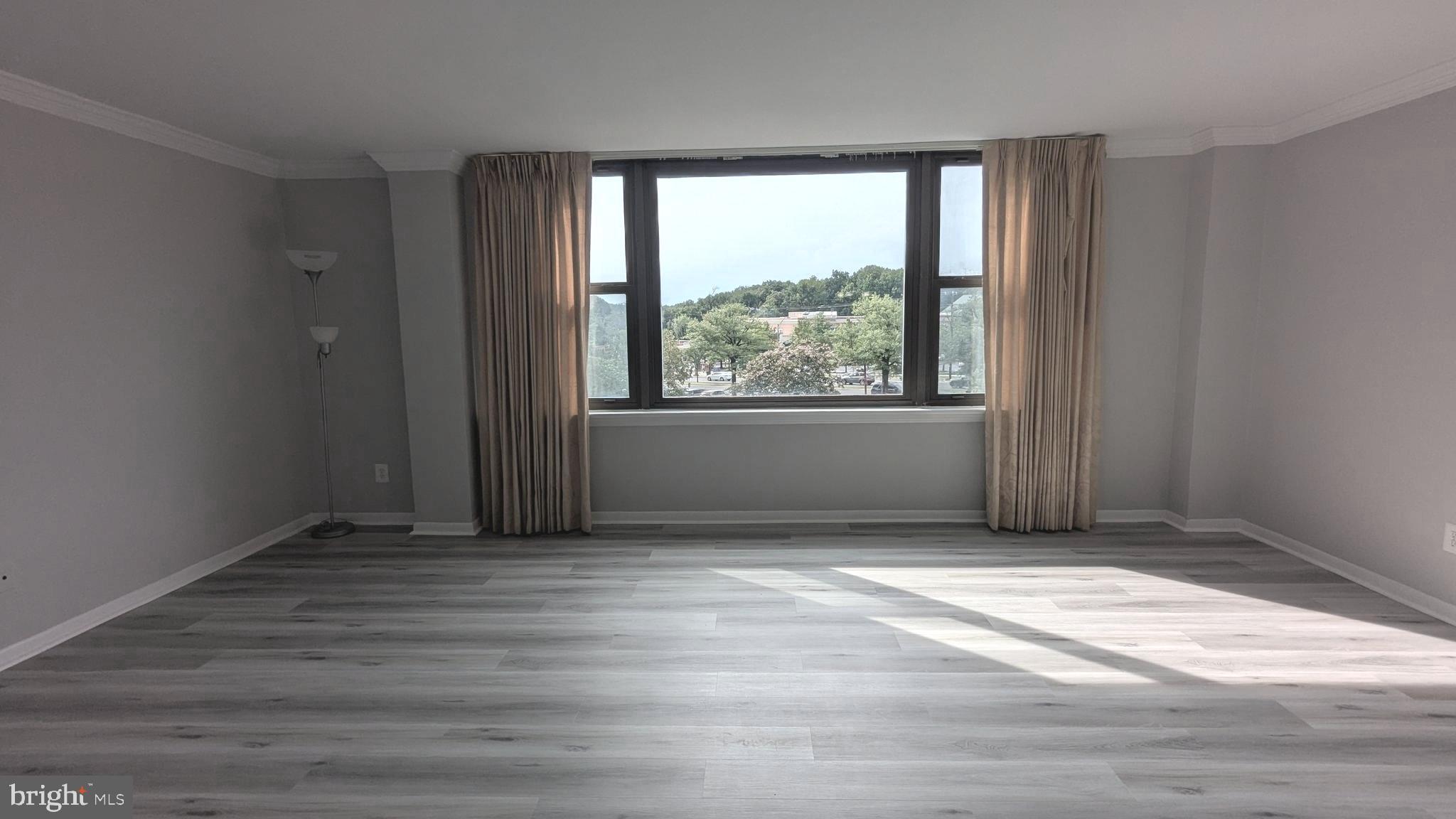4600 Duke Street, Unit 620 Alexandria, VA 22304 - Photo 10 of 40 an empty room with wooden floor and windows