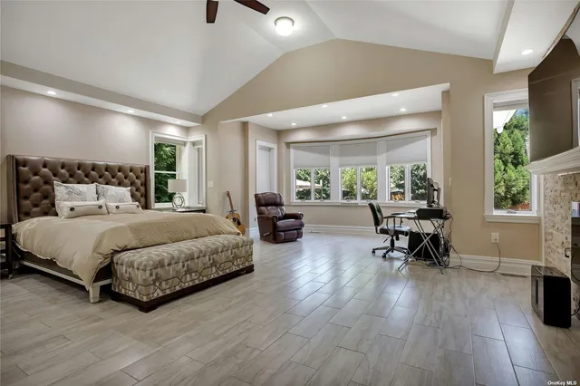 a spacious bedroom with a bed a table and a potted plant