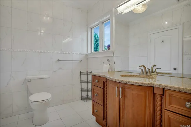 a bathroom with a granite countertop sink a toilet and mirror