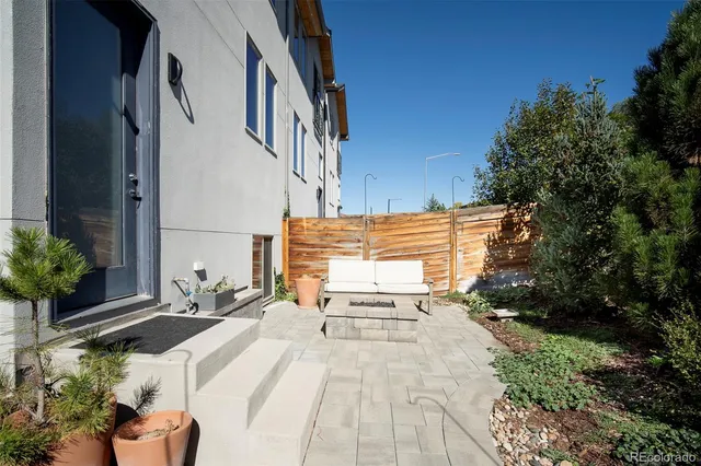 a view of a patio with couches table and chairs and potted plants