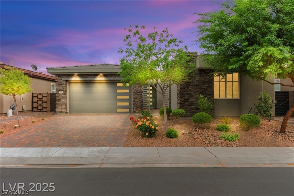 103 Reflection Cove Drive Henderson, NV 89011 - Photo 1 of 66 View of front of home featuring stone siding, decorative driveway, a garage, and stucco siding