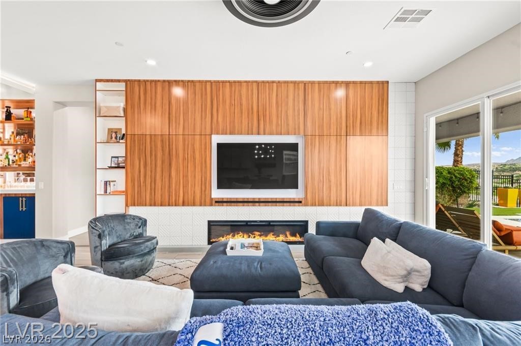103 Reflection Cove Drive Henderson, NV 89011 - Photo 11 of 66 Living room featuring wood finished floors, a glass covered fireplace, and recessed lighting