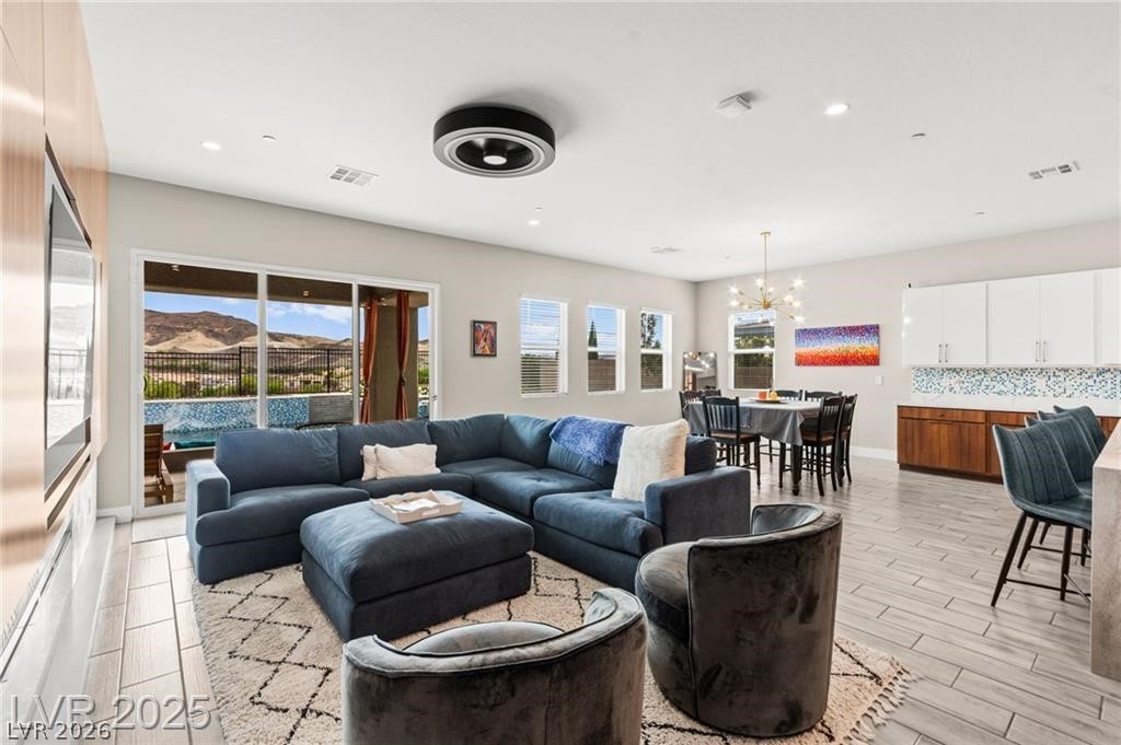103 Reflection Cove Drive Henderson, NV 89011 - Photo 14 of 66 Living area featuring wood finish floors, a chandelier, and recessed lighting